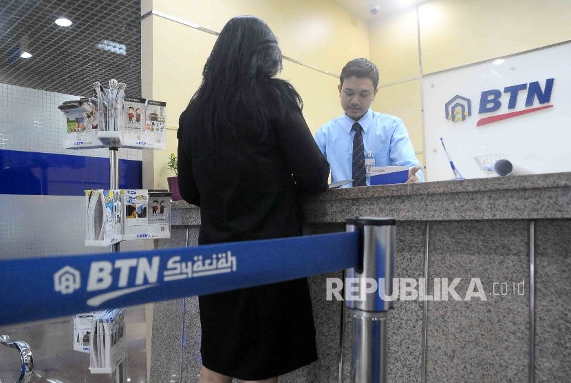  Karyawan melayani nasabah di banking Hall bank BTN Syariah, Jakarta, Selasa (24/1).