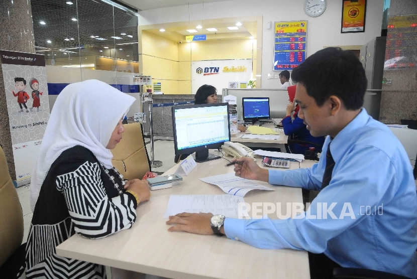 Karyawan melayani nasabah di Banking Hall Bank BTN Syariah, Jakarta, Kamis (12/1).
