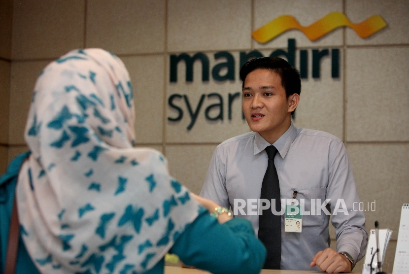 Karyawan melayani nasabah di Banking Hall Bank Syariah Mandiri (BSM) cabang Pasar Baru, Jakarta, Kamis (27/7). 