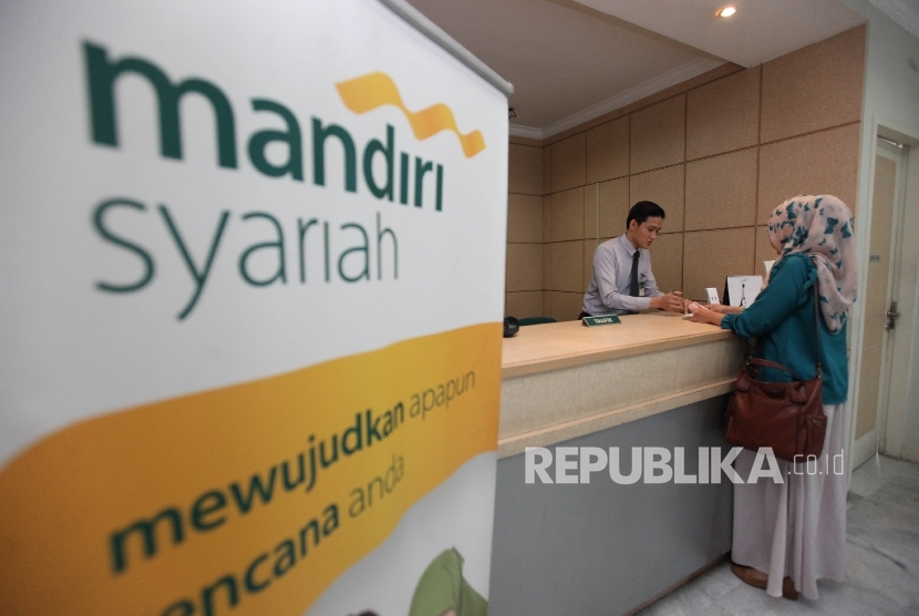 Karyawan melayani nasabah di Banking Hall Bank Syariah Mandiri (BSM) cabang Pasar Baru, Jakarta, Kamis (27/7).