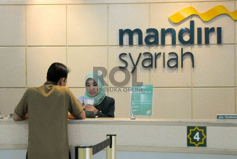 Karyawan melayani nasabah di Banking Hall Gedung Bank Syariah Mandiri (BSM), Jakarta, Rabu (30/9).