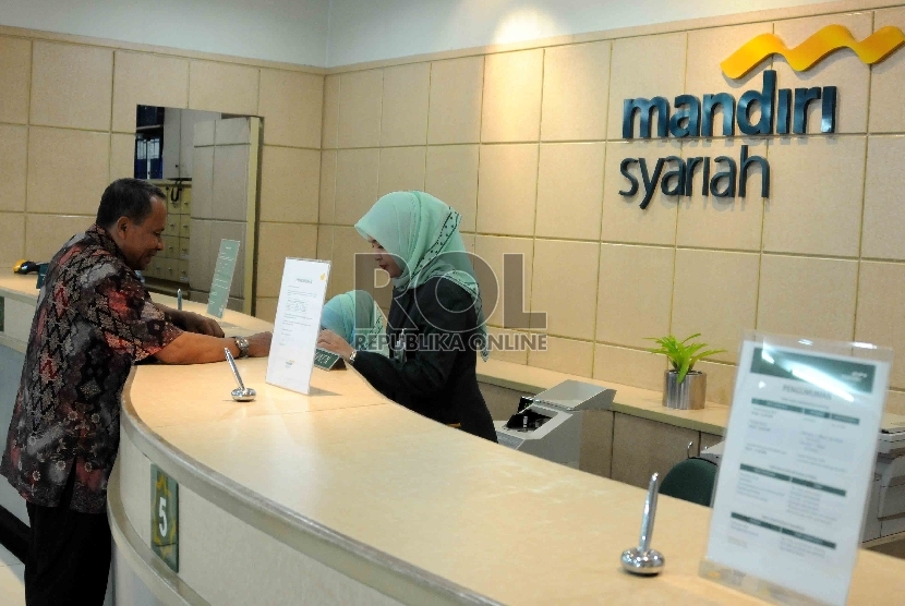 Karyawan melayani nasabah di Banking Hall Gedung Bank Syariah Mandiri (BSM), Jakarta, Rabu (30/9).