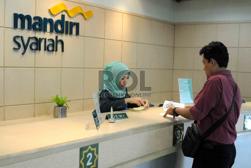 Karyawan melayani nasabah di Banking Hall Gedung Bank Syariah Mandiri (BSM), Jakarta, Rabu (30/9). 