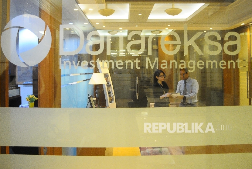  Karyawan melayani nasabah di Gedung Danareksa Investment Management, Jakarta, Senin (21/3). 