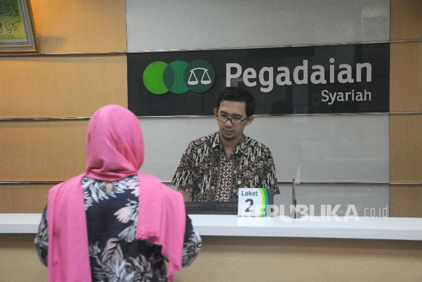 Karyawan melayani nasabah di kantor pelayanan Pegadaian Syariah, Jakarta, Jumat (24/3).