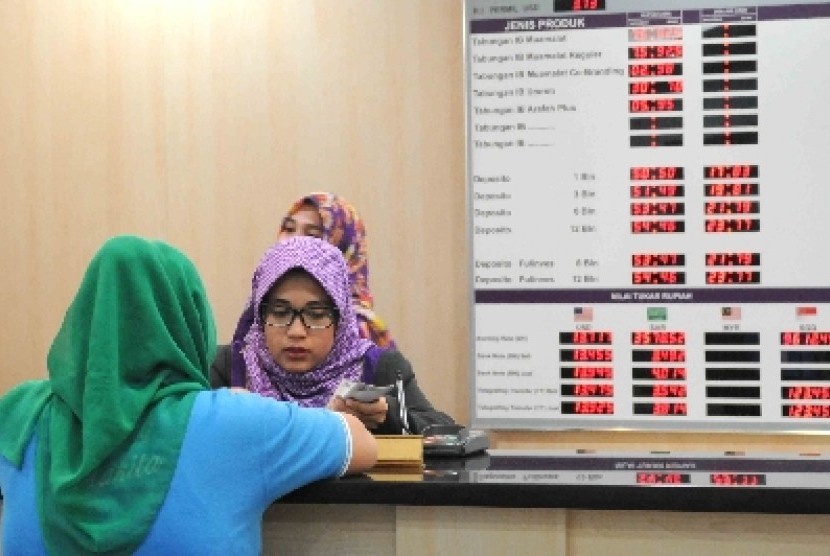 Karyawan melayani nasabah disalah satu Bank Syariah di Jakarta, Jumat (6/11).
