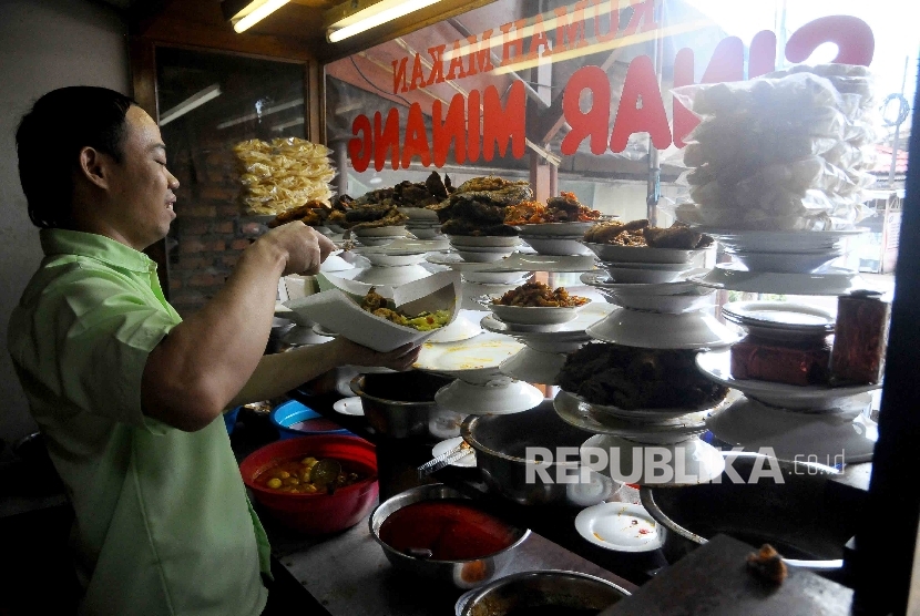  Karyawan melayani pembeli nasi padang di Kawasan Jalan Sabang, Jakarta, Ahad (8/1).