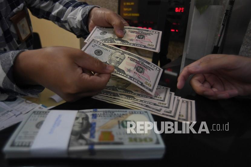 Karyawan melayani pembelian uang dolar Amerika Serikat (AS) di sebuah tempat penukaran uang di Jakarta, Jumat (20/11). Dolar AS sedikit melemah di perdagangan Asia pada Senin (14/12) pagi, menjelang pertemuan dua hari Federal Reserve AS yang berakhir Rabu (16/12). 
