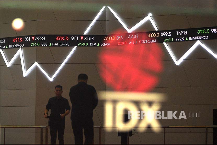 Karyawan melintas di bawah monitor pergerakan Indeks Harga Saham Gabungan (IHSG) Bursa Efek Indonesia, Jakarta. ilustrasi