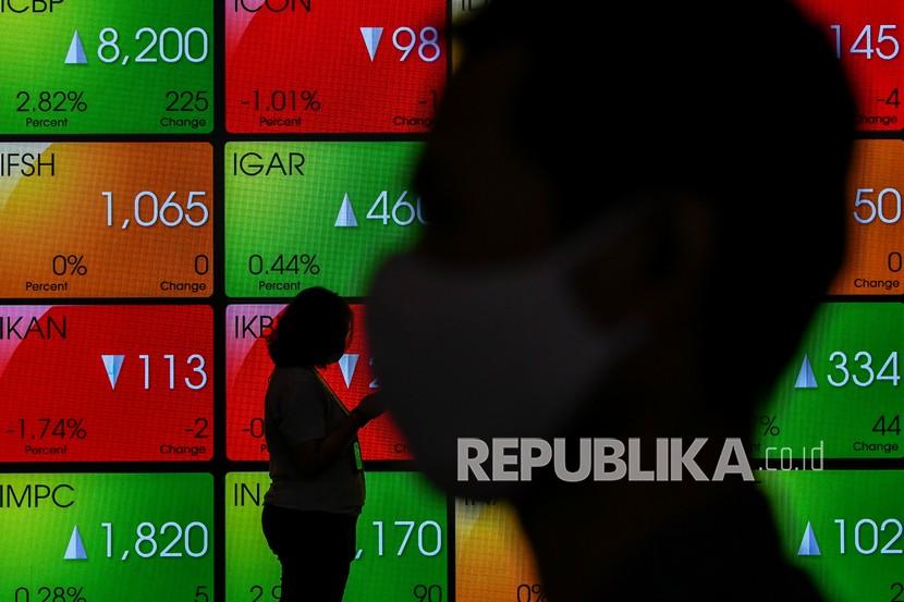 Karyawan melintas di dekat layar monitor pergerakan Indeks Harga Saham Gabungan (IHSG) di Bursa Efek Indonesia, Jakarta, beberapa waktu lalu.