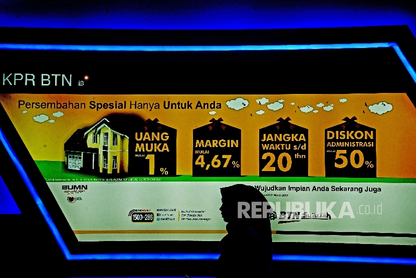Karyawan melintas didepan layar promosi di Stand Bank BTN pada pameran Indonesia Property Expo (IPEX) 2017 di Jakarta Convention Center (JCC), Senayan, Jakarta, Ahad (19/2).