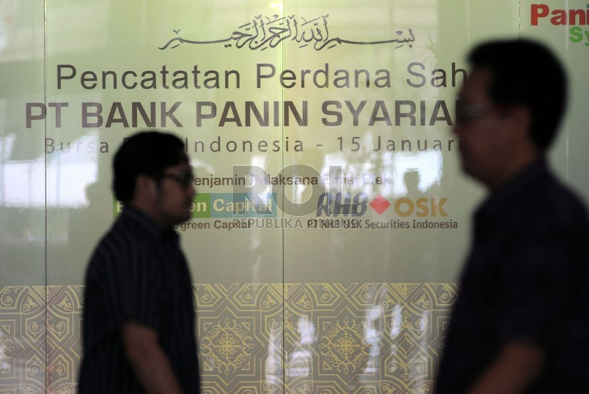   Karyawan melintas saat acara pencatatan saham perdana Bank Panin Syariah di Bursa Efek Indonesia (BEI), Jakarta, Rabu (15/1).    (Republika/Aditya Pradana Putra)