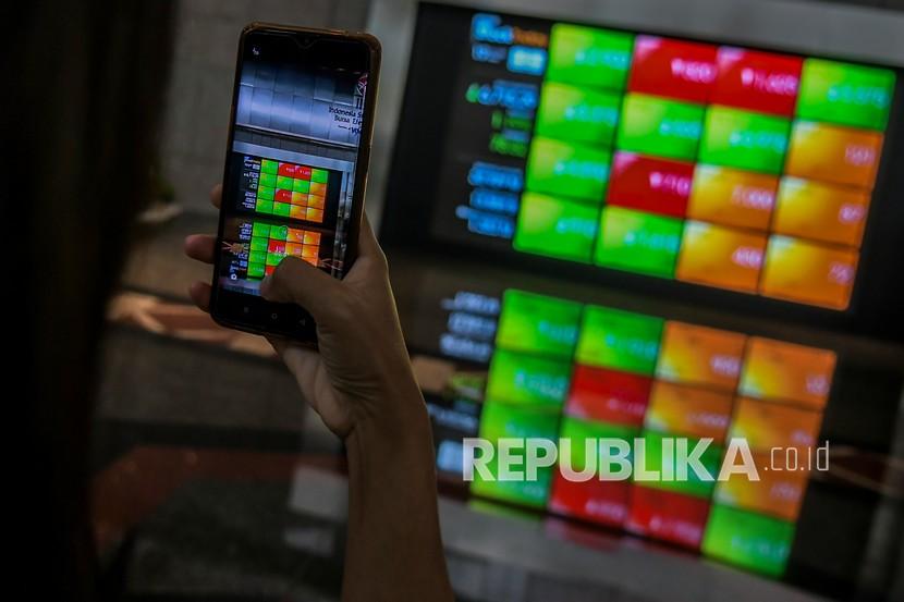 Karyawan memotret layar pergerakan Indeks Harga Saham Gabungan (IHSG) di gedung Bursa Efek Indonesia, Jakarta, Jumat (19/11). Saham-saham Asia jatuh pada awal perdagangan Jumat (26/11), dan menuju penurunan mingguan terbesar dalam hampir dua bulan. 