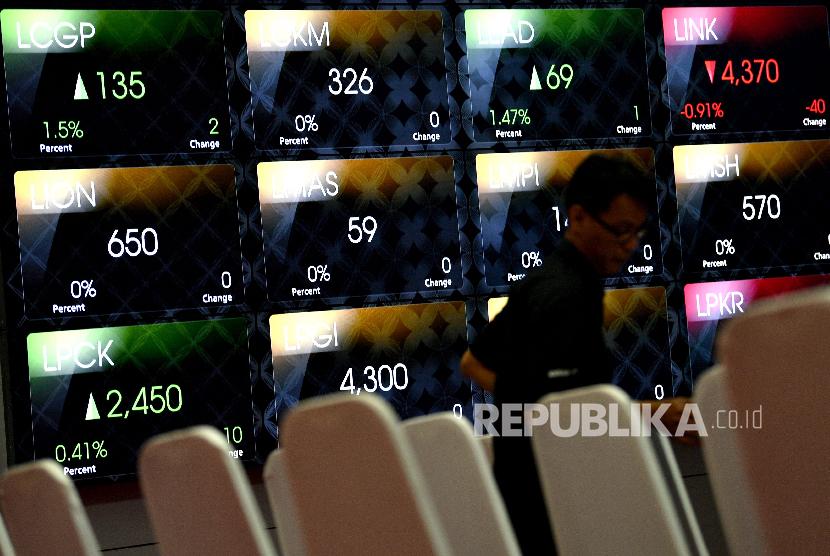 Karyawan menata kursi di depan monitor pergerakan Indeks Harga Saham Gabungan (IHSG) di Bursa Efek Indonesia, Jakarta, Jumat (25/1).