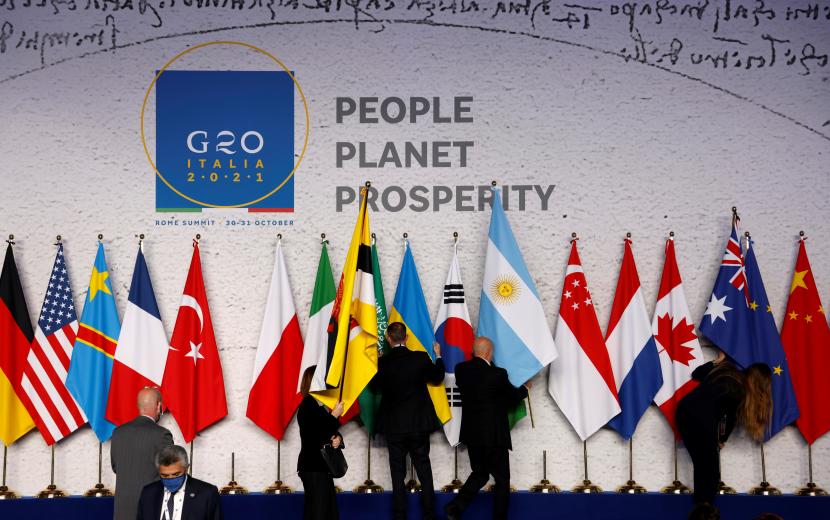  Karyawan mengatur bendera nasional dan membuat persiapan terakhir sebelum para pemimpin dunia berkumpul untuk foto keluarga resmi pada hari pertama KTT G20 di pusat konvensi La Nuvola, di distrik EUR Roma, Italia, 30 Oktober 2021.