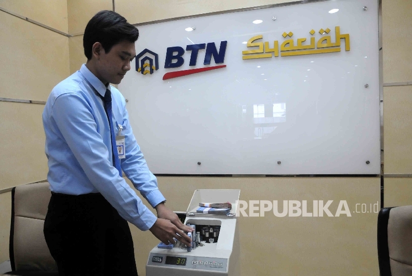 Karyawan menghitung uang di Banking Hall bank BTN Syariah, Jakarta, Senin (18/4).  (Republika/Agung Supriyanto)