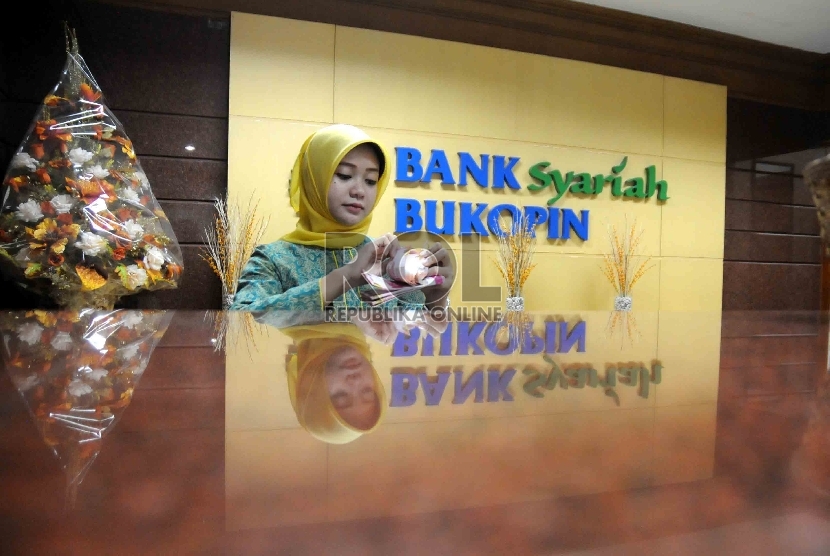 Karyawan menghitung uang di banking hall Bank Syariah Bukopin, Jakarta, beberapa waktu lalu. 