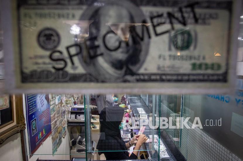 Karyawan menghitung uang di salah satu gerai penukaran uang asing di Jakarta, Jumat (6/11/2020). 