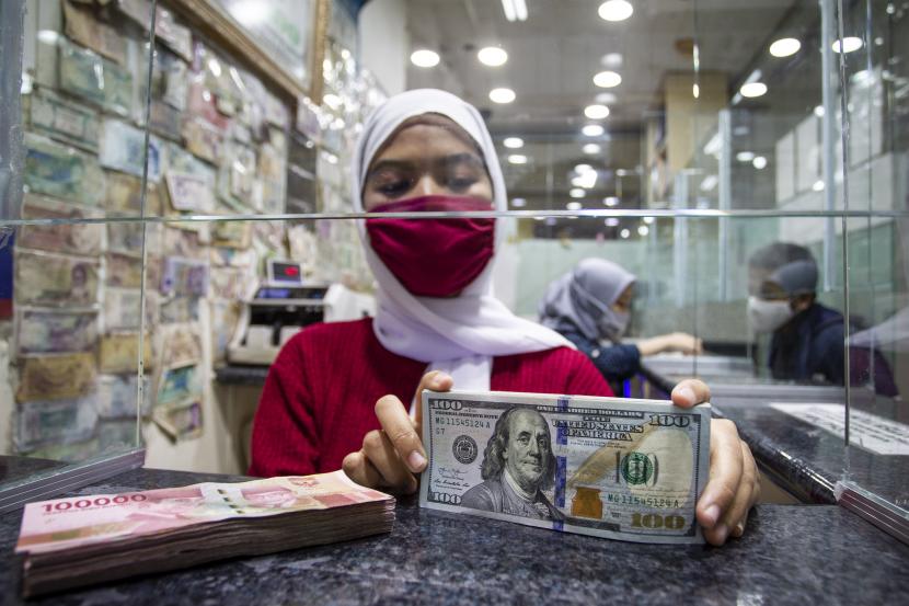 Karyawan menghitung uang pecahan 100 dolar AS di salah satu gerai penukaran uang asing, di Jakarta, Selasa (29/9/2020).