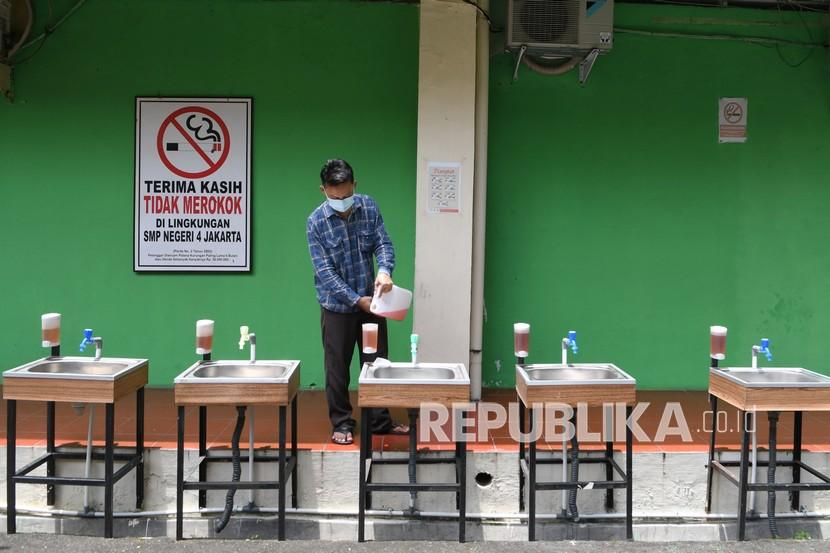 Karyawan mengisi ulang sabun cair di wastafel Sekolah Menengah Pertama (SMP). Ilustrasi