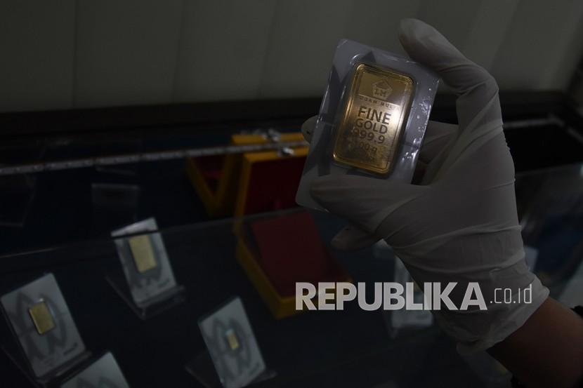 Karyawan menunjukan emas batangan yang dijual di Butik Emas Antam, Kebon Sirih, Jakarta, Jumat (11/9). Rapat Umum Pemegang Saham Luar Biasa (RUPSLB) PT Aneka Tambang Tbk atau Antam menetapkan Nicolas Kanter sebagai direktur utama baru. 