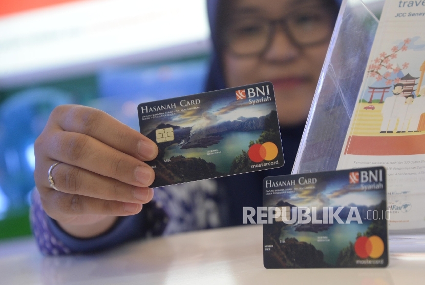 Karyawan menunjukkan Kartu BNI IB Hasanah Card spesial desain Lombok saat peluncuran, Jakarta, Jumat (22/9).