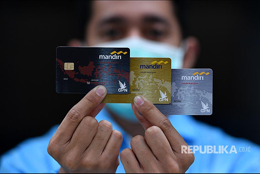 Karyawan menunjukkan kartu debit berlogo gerbang pembayaran nasional (GPN)