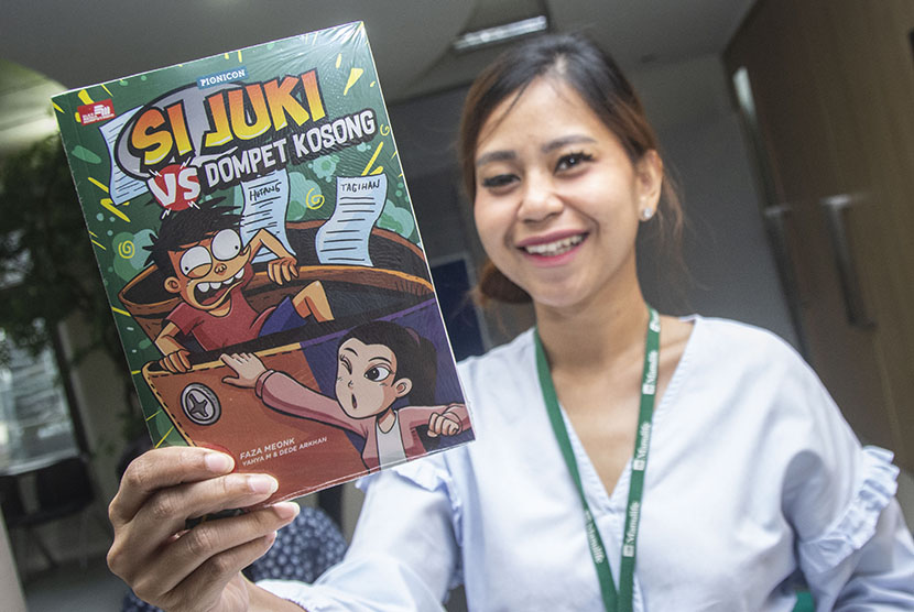 Karyawan menunjukkan komik Si Juki vs Dompet Kosong ketika peluncuran di Jakarta, Kamis (24/5). 