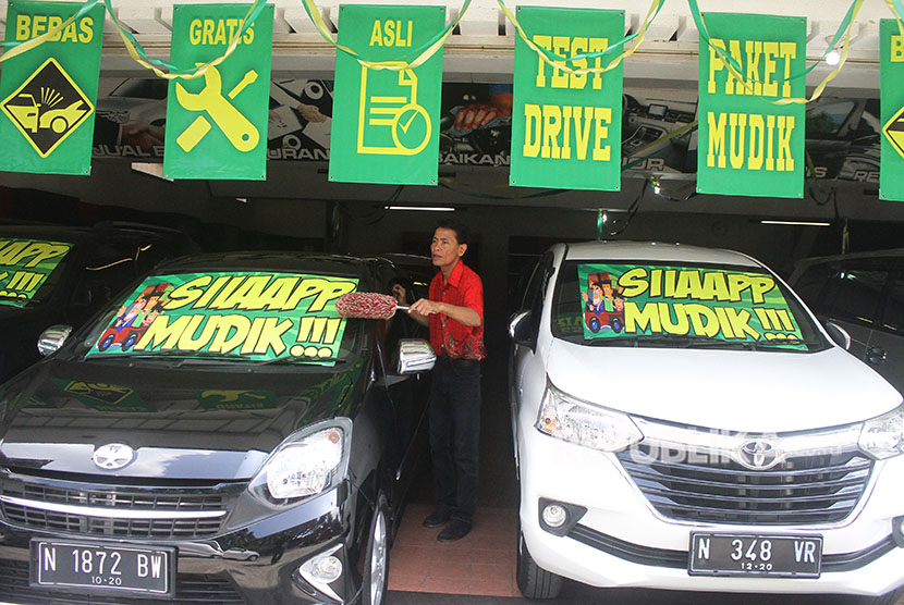 Karyawan pemasaran membersihkan mobil bekas yang dijual di sebuah ruang pamer pusat penjualan mobil bekas di Malang, Jawa Timur, Jumat (8/6).