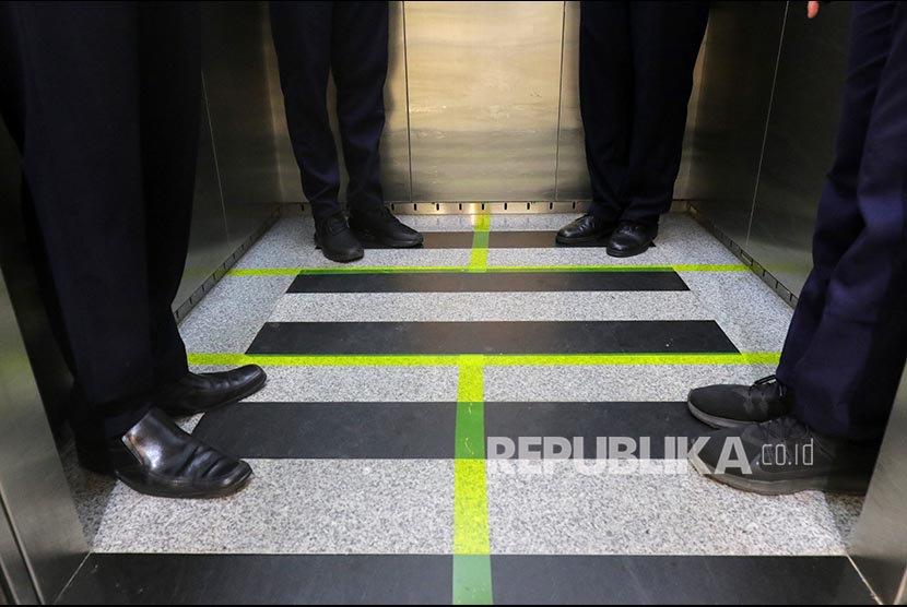Karyawan PT Angkasa Pura II (Persero) menggunakan lift yang telah diberi stiker panduan jarak, di Bandara Depati Amir, Pangkalpinang, Kepulauan Bangka Belitung, Kamis (19/3).