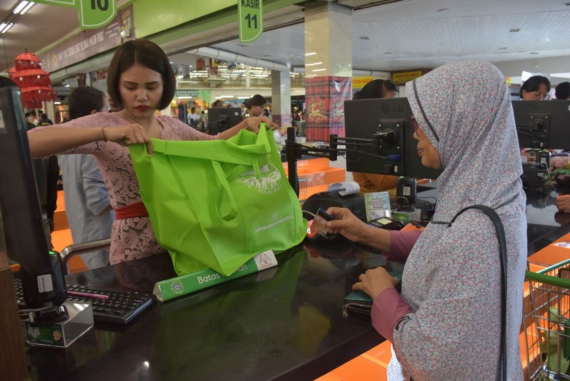Karyawan swalayan mengemas barang belanjaan konsumen dengan tas ramah lingkungan di pusat perbelajaan di Denpasar, Bali, Kamis (3/1/2019).