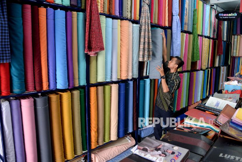 Karyawan Toko Mutiara Textile  menata gulungan kain di Pasar Minggu, Jakarta,Jumat(7/12). Kementerian Perindustrian menargetkan pada 2019 ekspor tekstil dan produk tekstil (TPT) mencapai US$15 miliar dan mampu menyerap tenaga kerja sebanyak 3,11 juta orang.