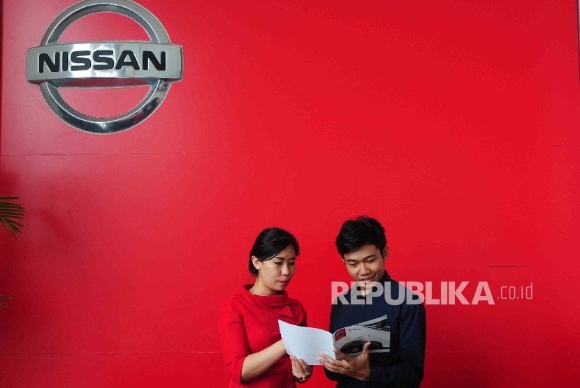 Karyawati melayani calon pembeli di diler PT Mitra Pinasthika Mustika Auto (MPM Auto) Nissan-Datsun di Alam Sutra, Tanggerang, Banten, Senin (28/3).