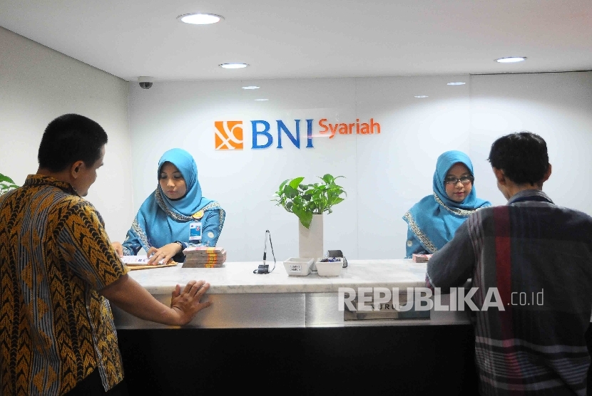  Karyawati melayani nasabah di Banking Hall Bank BNI Syariah, Jakarta, Rabu (18/1).