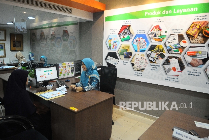  Karyawati melayani nasabah di banking hall Bank BNI Syariah, Jakarta, Jumat (10/2).