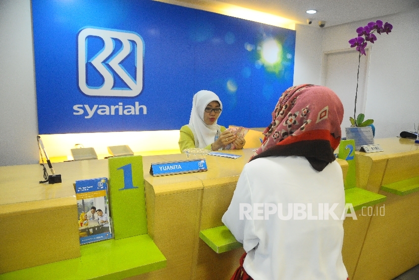  Karyawati melayani nasabah di Banking Hall Bank BRI Syariah, Jakarta, Kamis (9/2). P