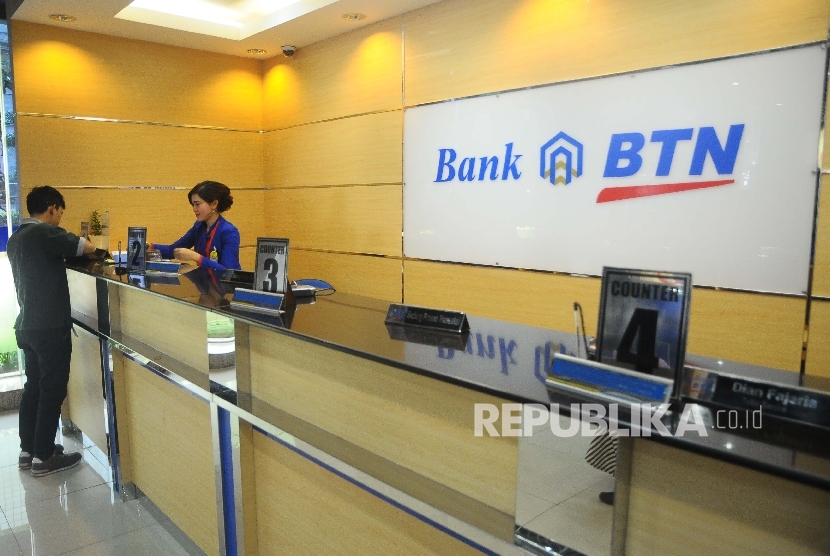  Karyawati melayani nasabah di banking Hall Bank BTN, Jakarta, Kamis (23/3). 