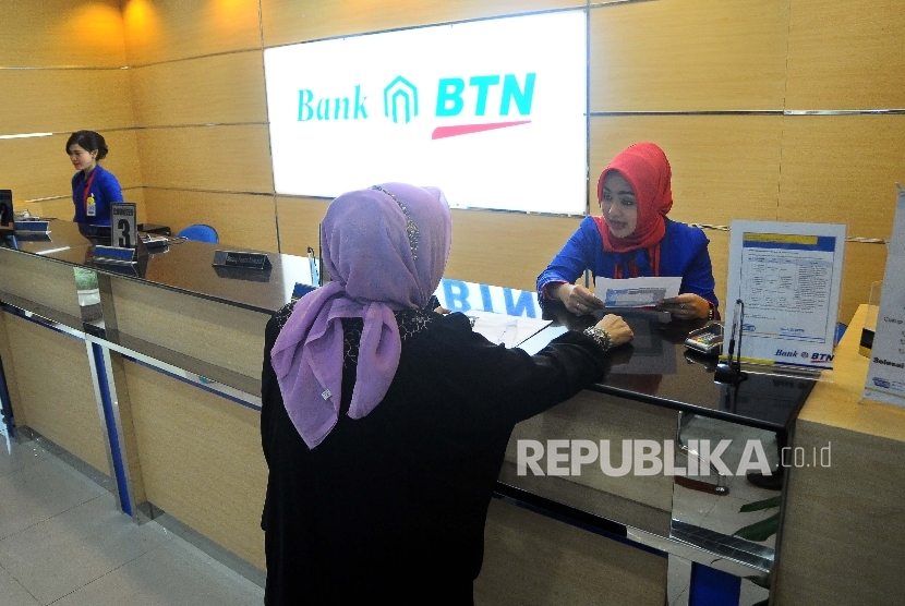  Karyawati melayani nasabah di banking Hall Bank BTN, Jakarta, Kamis (23/3). 