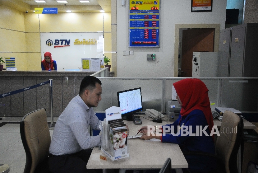 Karyawati melayani nasabah di Banking Hall Bank BTN, Jakarta, kamis (30/3). 