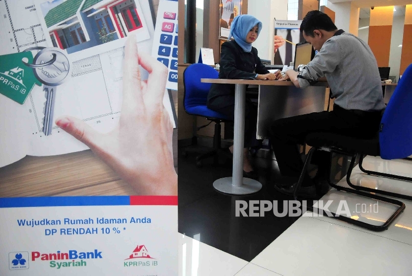 Karyawati melayani nasabah di banking Hall Bank Panin Syariah, Jakarta, Selasa (15/3).