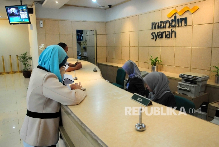  Karyawati melayani nasabah di Banking Hall Bank Syariah Mandiri, Jakarta, Selasa (20/9).