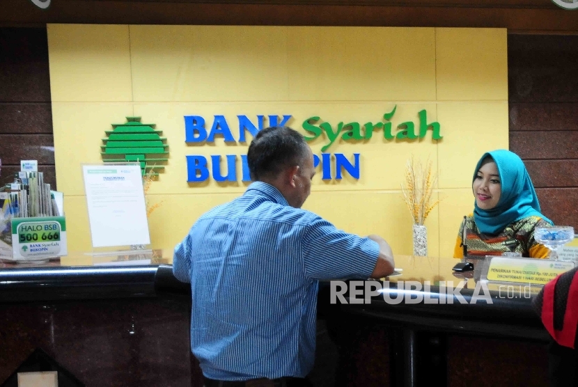  Karyawati melayani nasabah di Banking Hall Bank Syariah Bukopin, Jakarta.