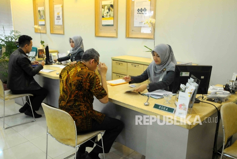 Karyawati melayani nasabah di banking Hall bank Syariah Mandiri (OBSM) di Jakarta, Jumat (20/1). 