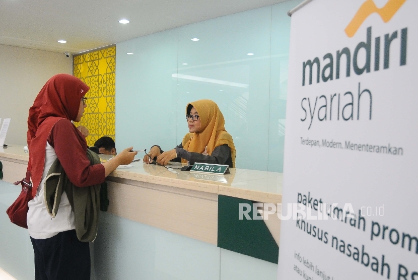 Karyawati melayani nasabah di Banking Hall Bank Syariah Mandiri, Jakarta, Senin (5/6).