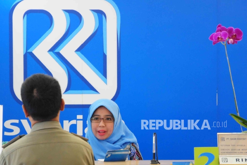  Karyawati melayani nasabah di Banking Hall BRI Syariah, Jakarta, Senin (7/3). 
