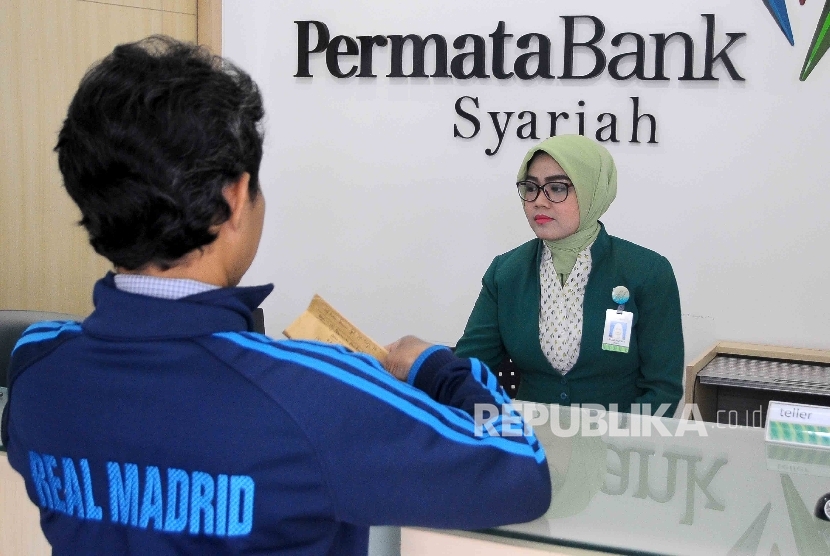 Karyawati melayani nasabah di Banking Hall Permata Bank Syariah, Jakarta, Selasa (10/1). 