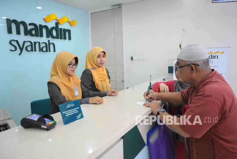 Karyawati melayani nasabah untuk melakukan pelunasan Biaya Penyelenggaraan Ibadah Haji (BPIH) di Banking Hall Bank Syariah mandiri (BSM) Cabang Mayestik, Jakarta, Senin (10/4).