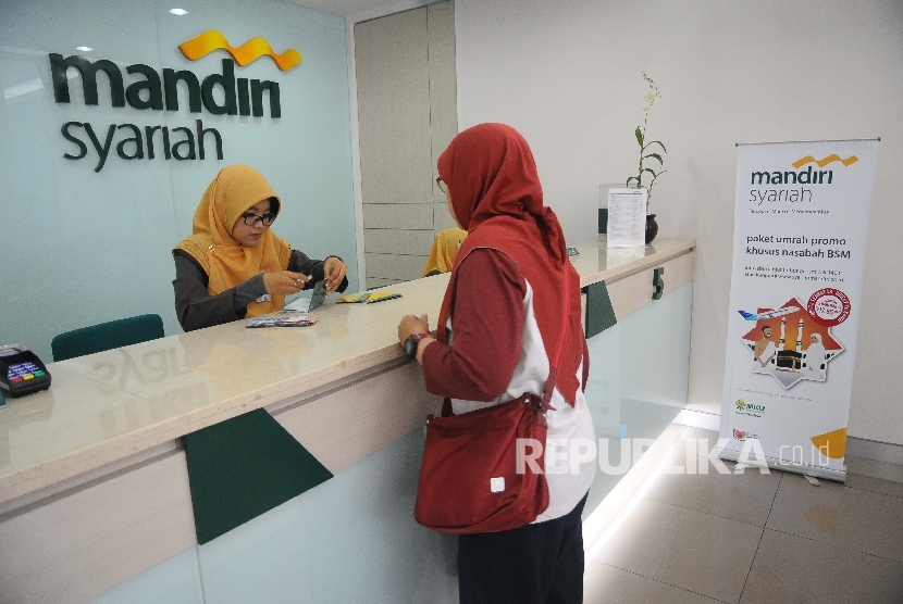 Karyawati melayanin nasabah untuk melakukan pelunasan Biaya Penyelenggaraan Ibadah Haji (BPIH) di Banking Hall Bank Syariah mandiri (BSM) Cabang Mayestik, Jakarta, Senin (10/4).