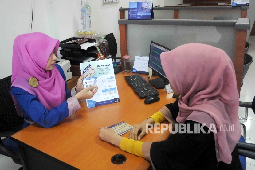 Karyawati menerangkan produk Bank Pembiayaan Rakyat Syariah (BPRS) di Gedung BPRS Al Salaam, Jakarta, Senin (9/1)
