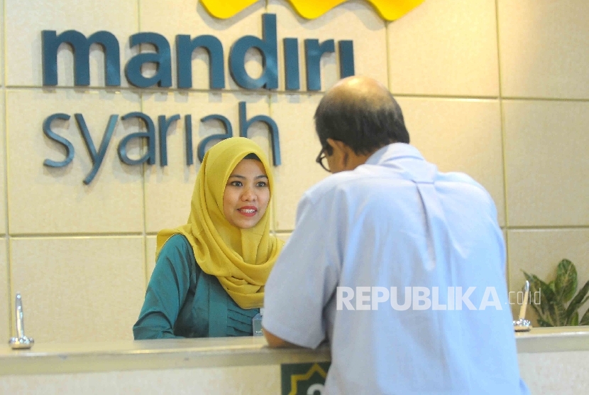 Karyawati mengenakan kebaya melayani nasabahnya di Banking Hall Bank Syariah Mandiri, Jakarta, Kamis (21/4).  (Republika/ Agung Supriyanto )